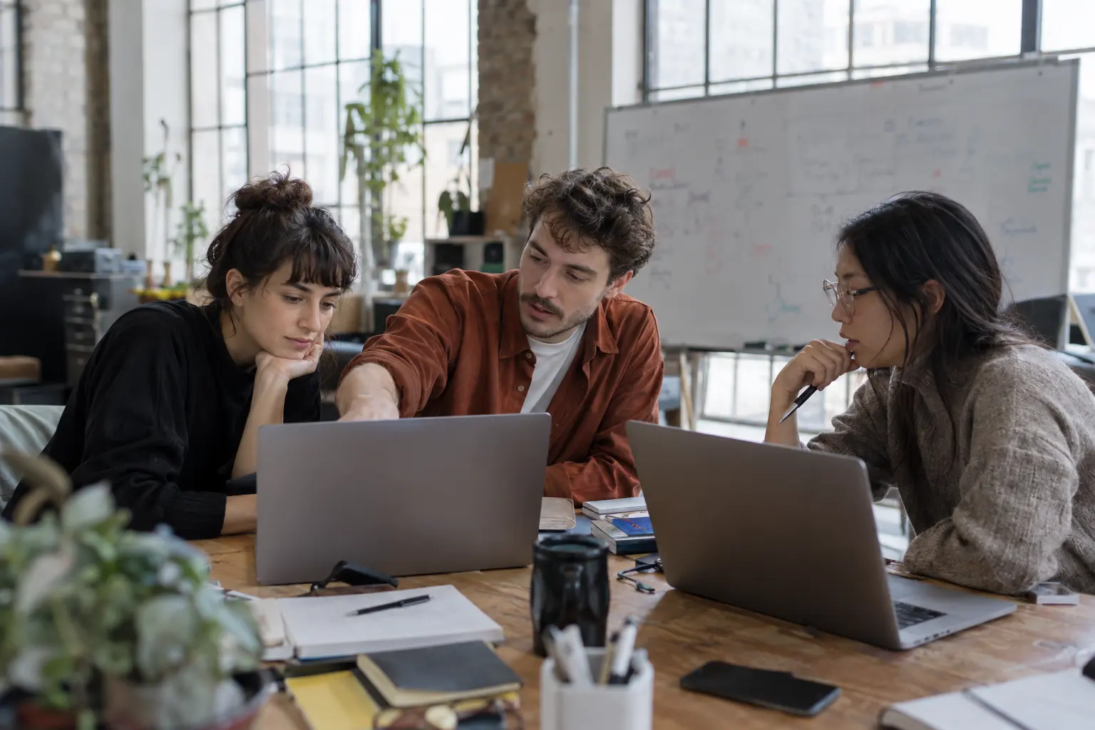 A small team working around one table with laptops